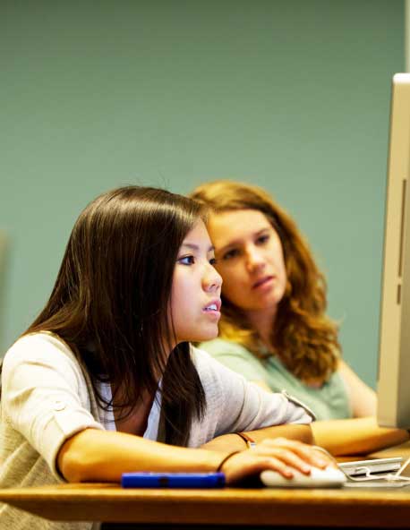 Two young women working at a computer